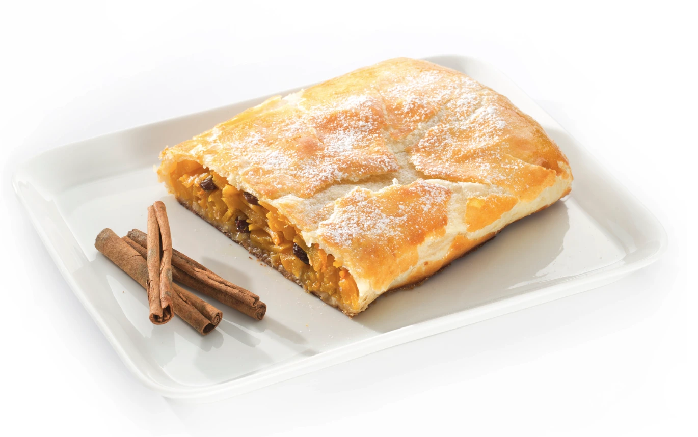 bučni zavitek na krožniku, zraven palčke cimeta