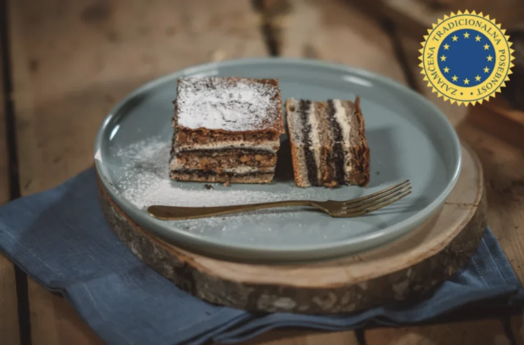 Prekmurska gibanica na krožniku, zraven označba zajamčena tradicionalna posebnost