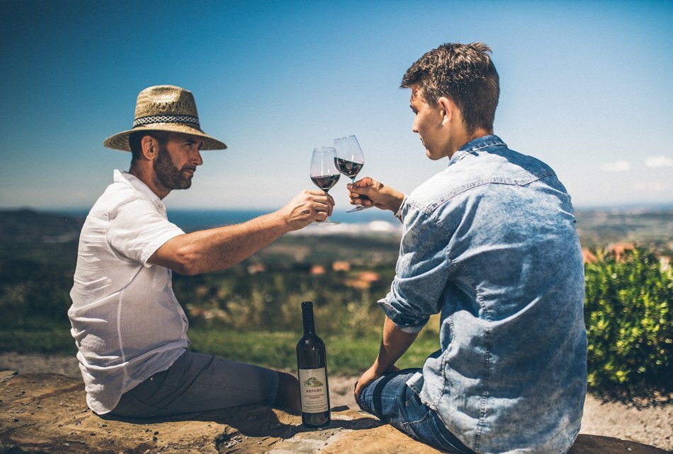 Oče in sin nazdravljata z vinom
