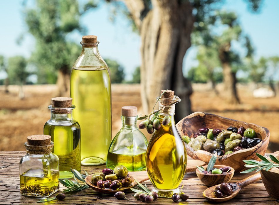 Oljčno olje na mizi - v ozadju oljčni nasad