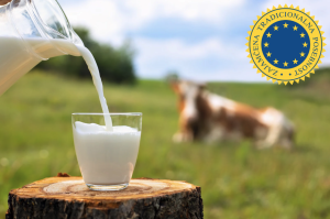 nalivanje mleka, v ozadju krava na pašniku, desno znak zajamčena tradicionalna posebnost